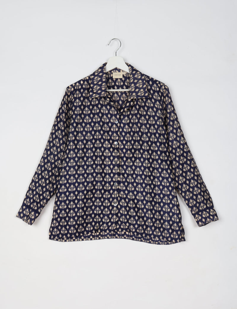 Blue resort shirt with beige micro floral design, long sleeves, button front, and collar, hanging on white hanger