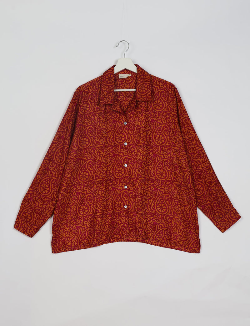 Red paisley patterned long-sleeve resort shirt with collar and white buttons, shown hanging on white hanger front view