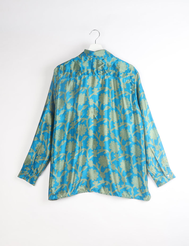 Blue long-sleeve resort shirt with green floral pattern, buttoned cuffs, shown from back on white hanger against white background