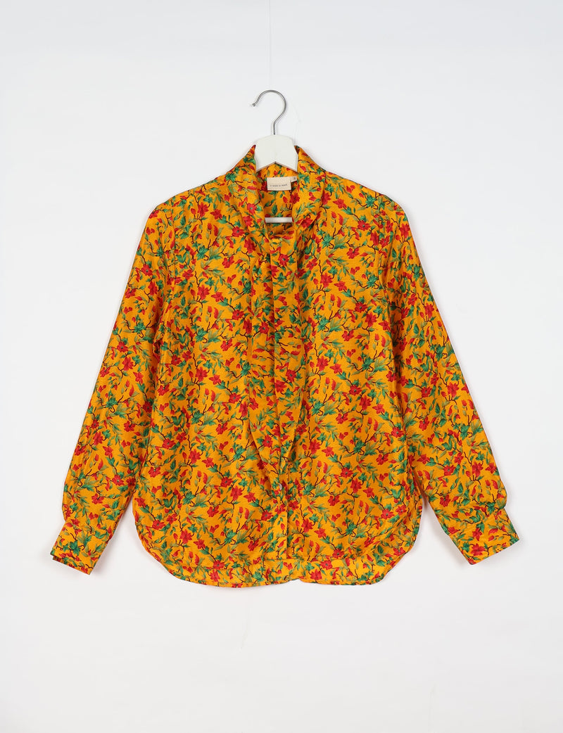 Yellow tropical floral bowtie shirt hanging on white hanger, front view
