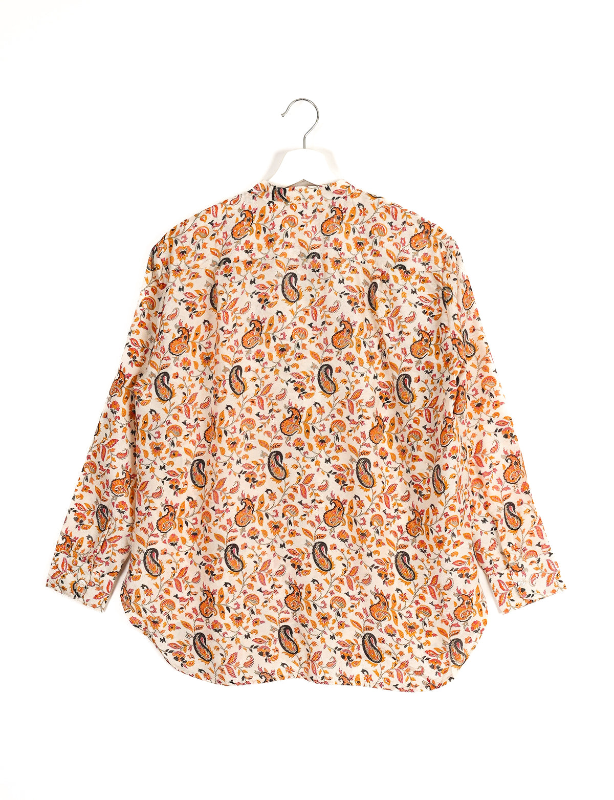 Longline white shirt with orange and black paisley floral print, long sleeves, and buttoned cuffs, shown from back on hanger