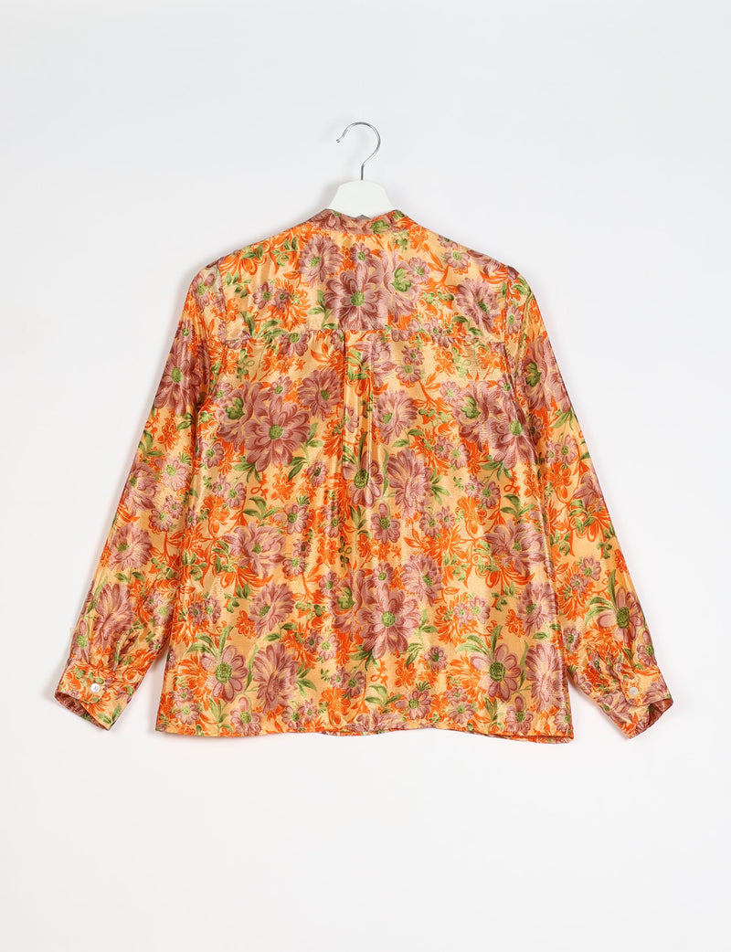 Yellow floral blouse with long sleeves and buttoned cuffs, shown from the back on a white hanger