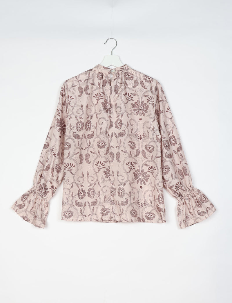 Beige blouse with brown tropical floral pattern, long sleeves with gathered cuffs, and back button closure, hanging flat
