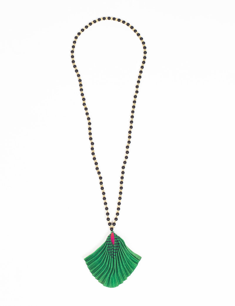 Long necklace with black and gold beads and a pleated green fan-shaped pendant with pink and black accents