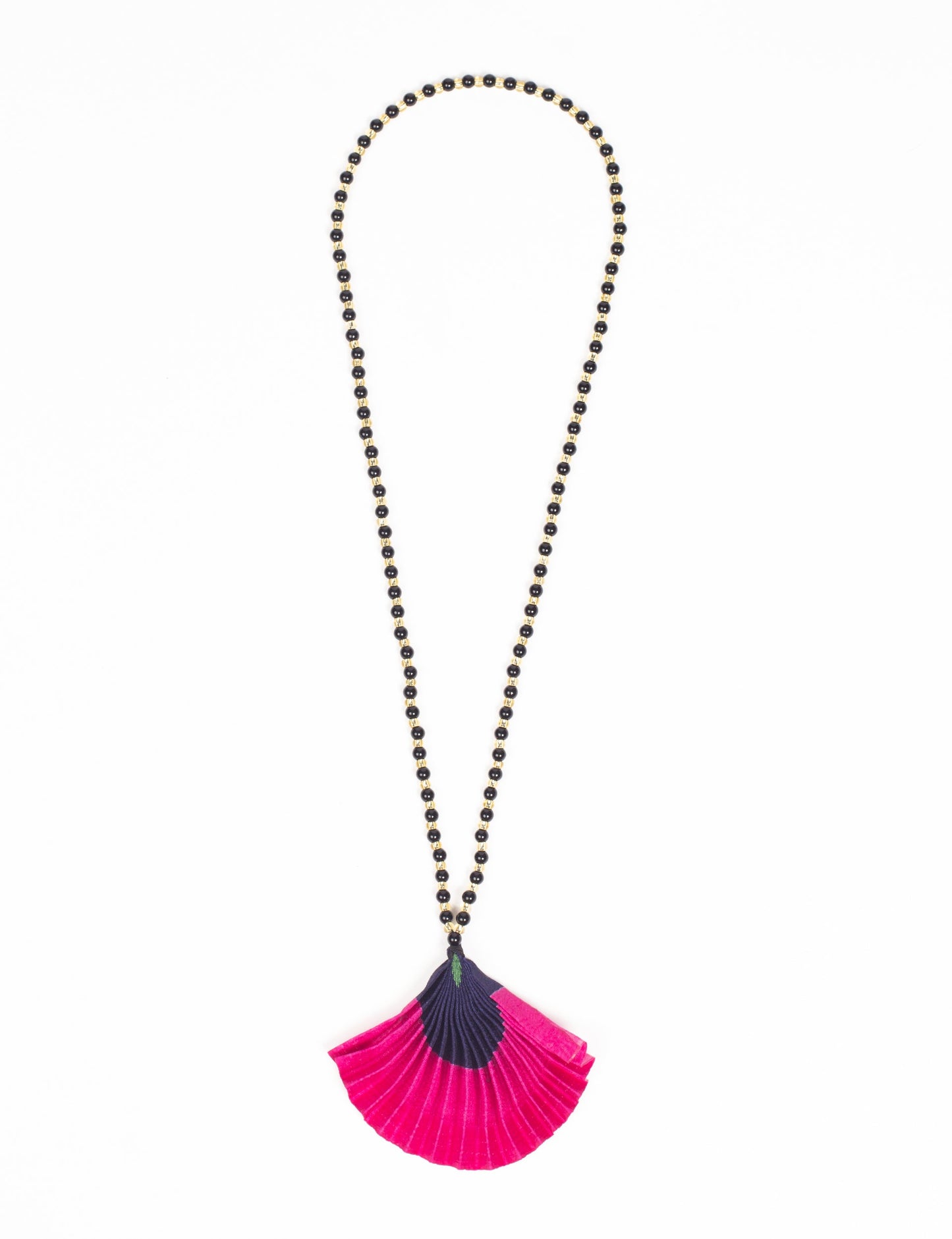 Dive into sustainable fashion with our PLEATED NECKLACE, a creation by talented female artisans in Mumbai. The pleated fan pendant, made from upcycled saris, hangs on a colorful necklace crafted from glass beads, embellished with sparkling glass crystals. An ethical, green fashion statement for conscious styling.