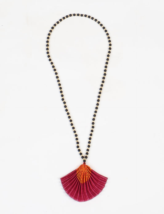 Dive into sustainable fashion with our PLEATED NECKLACE, a creation by talented female artisans in Mumbai. The pleated fan pendant, made from upcycled saris, hangs on a colorful necklace crafted from glass beads, embellished with sparkling glass crystals. An ethical, green fashion statement for conscious styling.