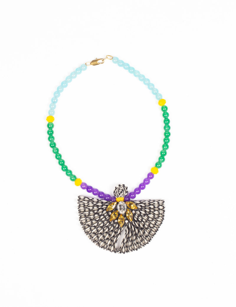Beaded necklace with blue, green, purple, and yellow beads, featuring a black and white pleated fabric pendant with yellow gems