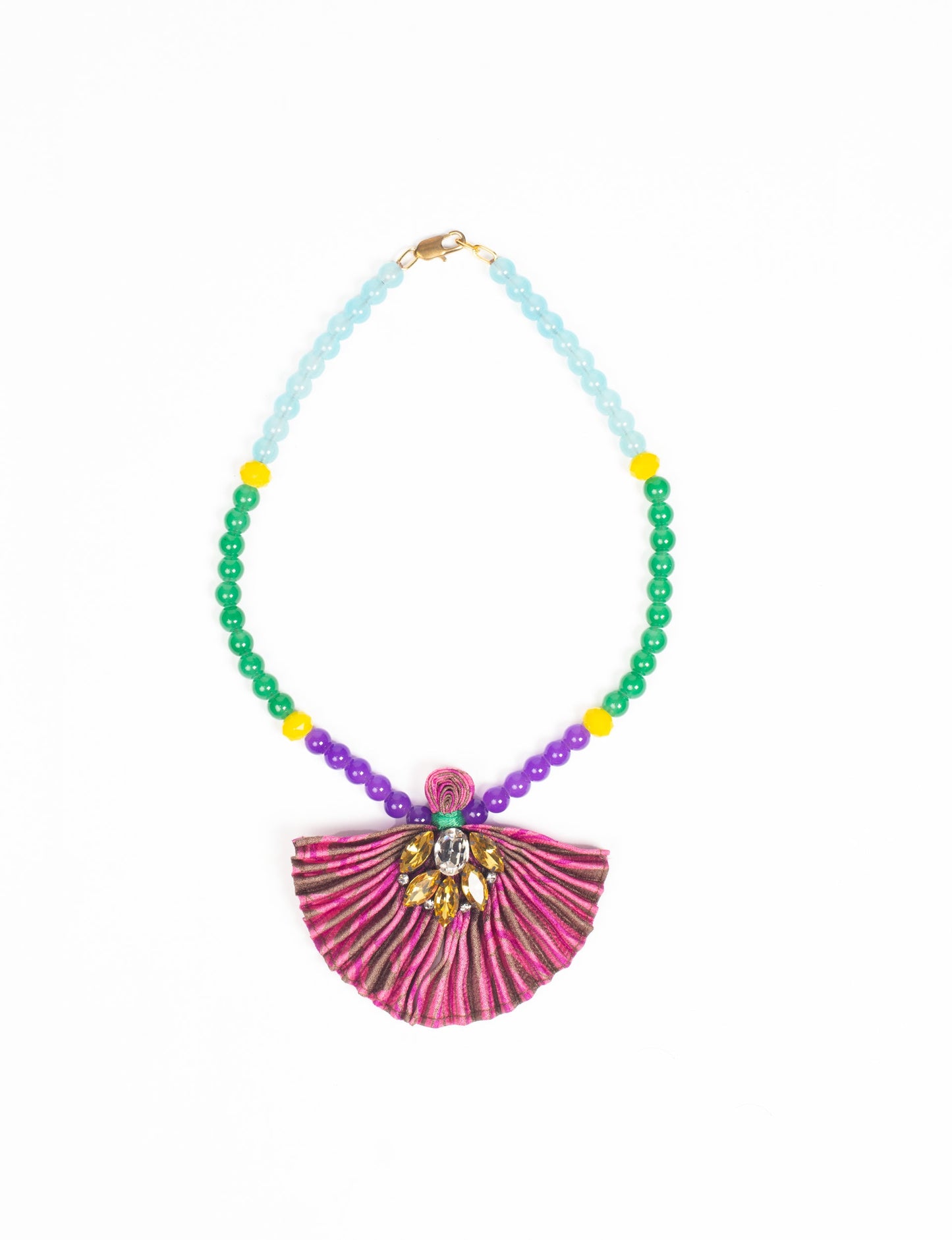 Dive into sustainable fashion with our PLEATED NECKLACE, a creation by talented female artisans in Mumbai. The pleated fan pendant, made from upcycled saris, hangs on a colorful necklace crafted from glass beads, embellished with sparkling glass crystals. An ethical, green fashion statement for conscious styling.