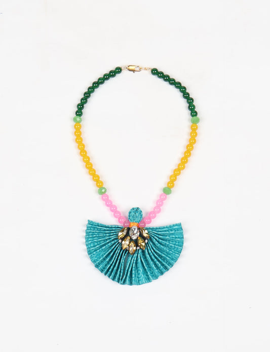 Dive into sustainable fashion with our PLEATED NECKLACE, a creation by talented female artisans in Mumbai. The pleated fan pendant, made from upcycled saris, hangs on a colorful necklace crafted from glass beads, embellished with sparkling glass crystals. An ethical, green fashion statement for conscious styling.