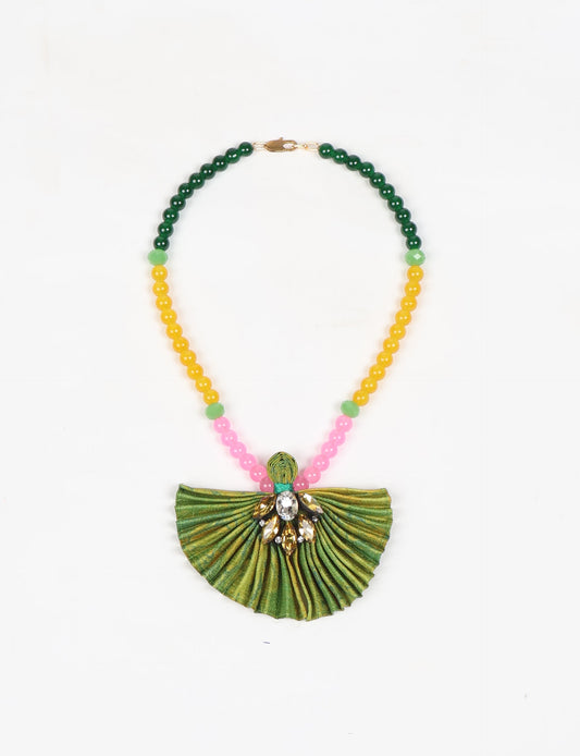 Dive into sustainable fashion with our PLEATED NECKLACE, a creation by talented female artisans in Mumbai. The pleated fan pendant, made from upcycled saris, hangs on a colorful necklace crafted from glass beads, embellished with sparkling glass crystals. An ethical, green fashion statement for conscious styling.