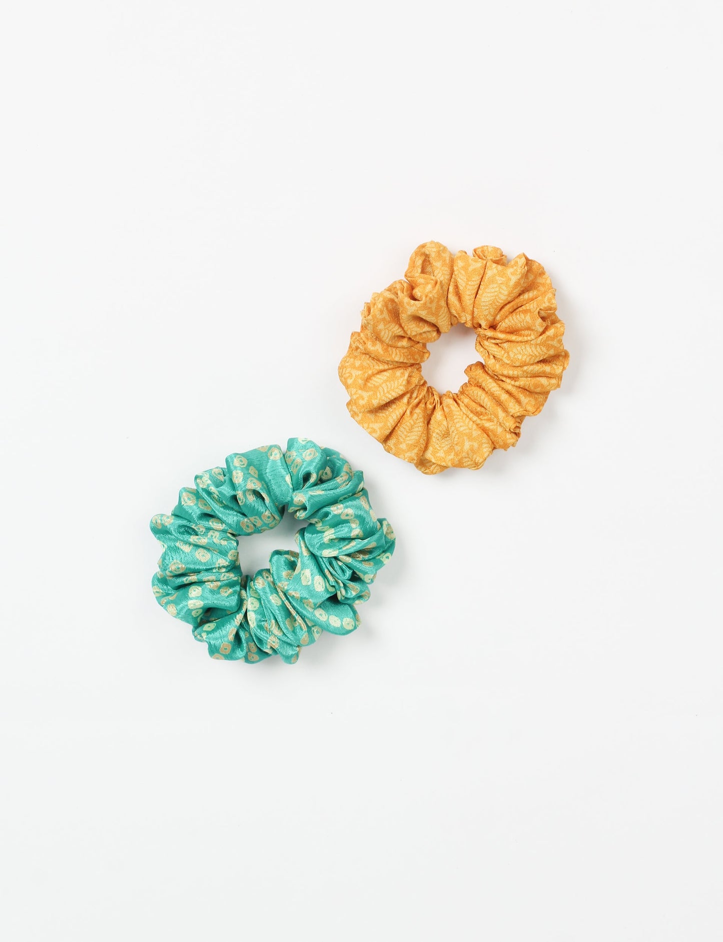 Upgrade your hairstyle with our Scrunchy Set of 2 – elastic hair ties wrapped in colorful Indian sari fabric. A top pick in ethical and green fashion, these eco-friendly prints add flair to your wrist and hair, making a sustainable style statement that catches attention and sparks change.