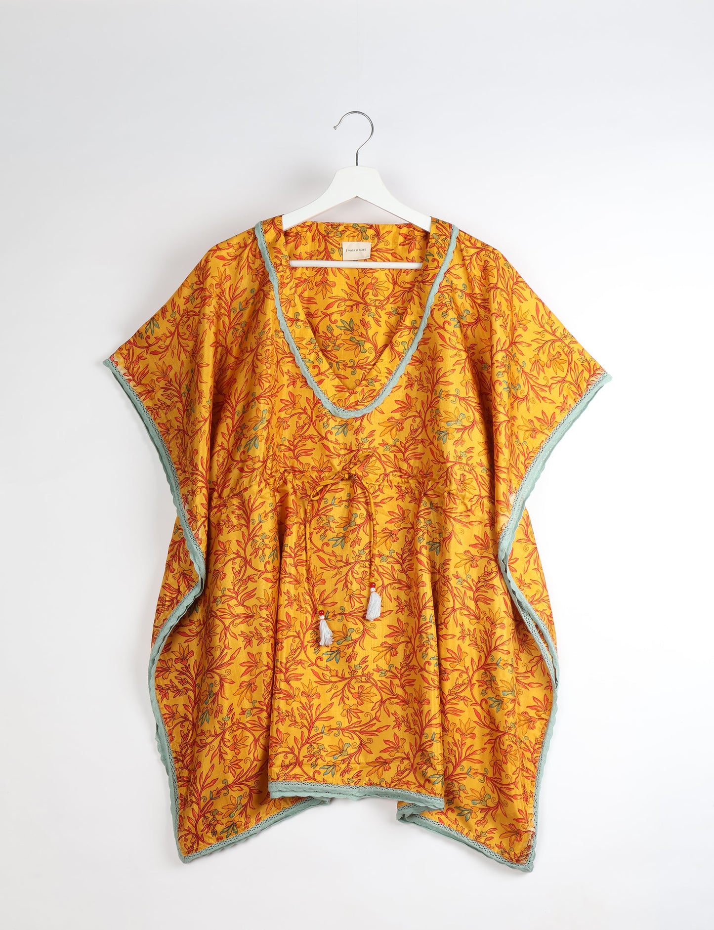 Elevate your style with our short kaftan, a perfect blend of ethical and green fashion. The light and loose-flowing fabric, drawstring waist, beaded tassel ends, and delicate lace edging make it a versatile choice for urban summers, beachwear, or poolside elegance. Enjoy sustainable and fashionable living.