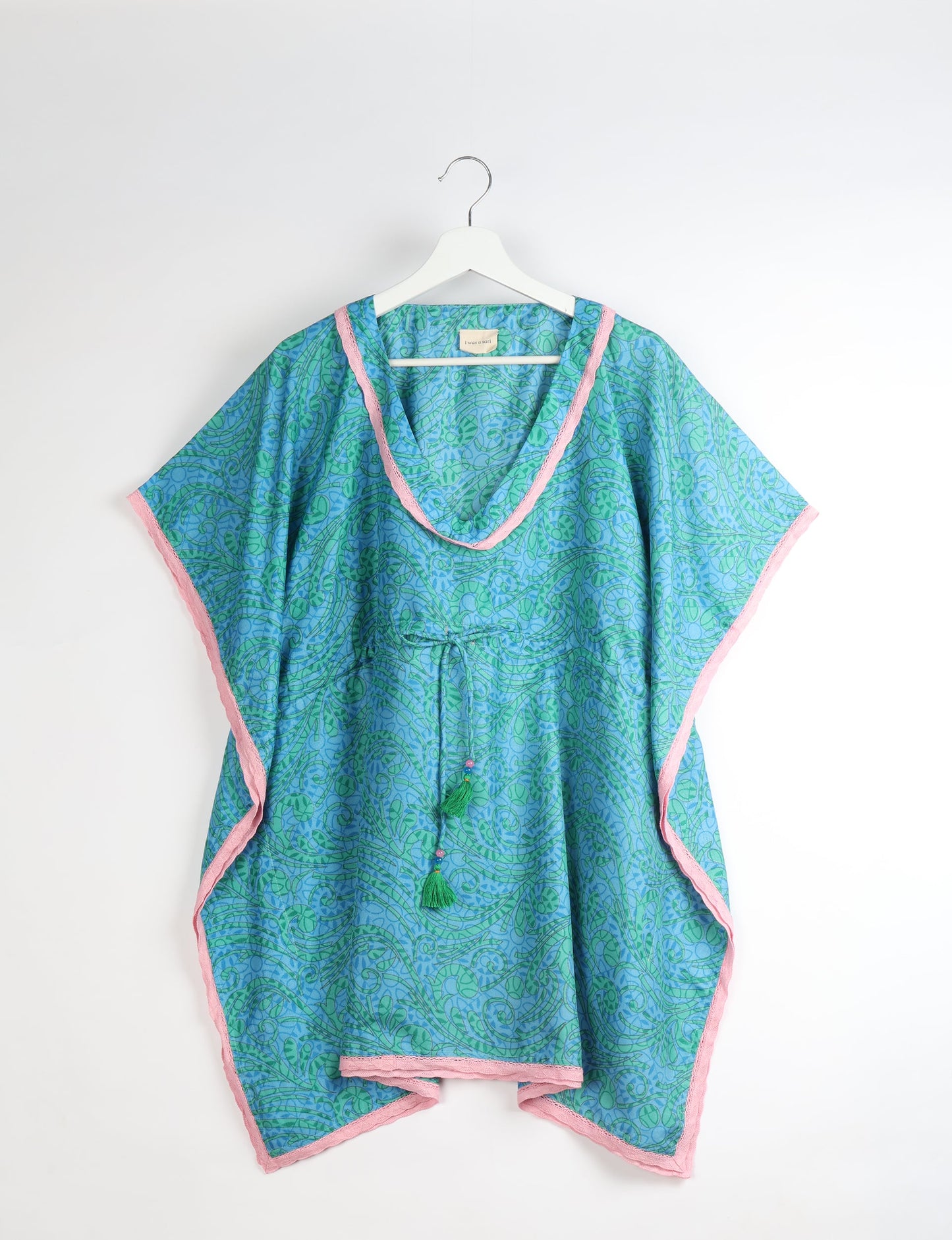 Elevate your style with our short kaftan, a perfect blend of ethical and green fashion. The light and loose-flowing fabric, drawstring waist, beaded tassel ends, and delicate lace edging make it a versatile choice for urban summers, beachwear, or poolside elegance. Enjoy sustainable and fashionable living.