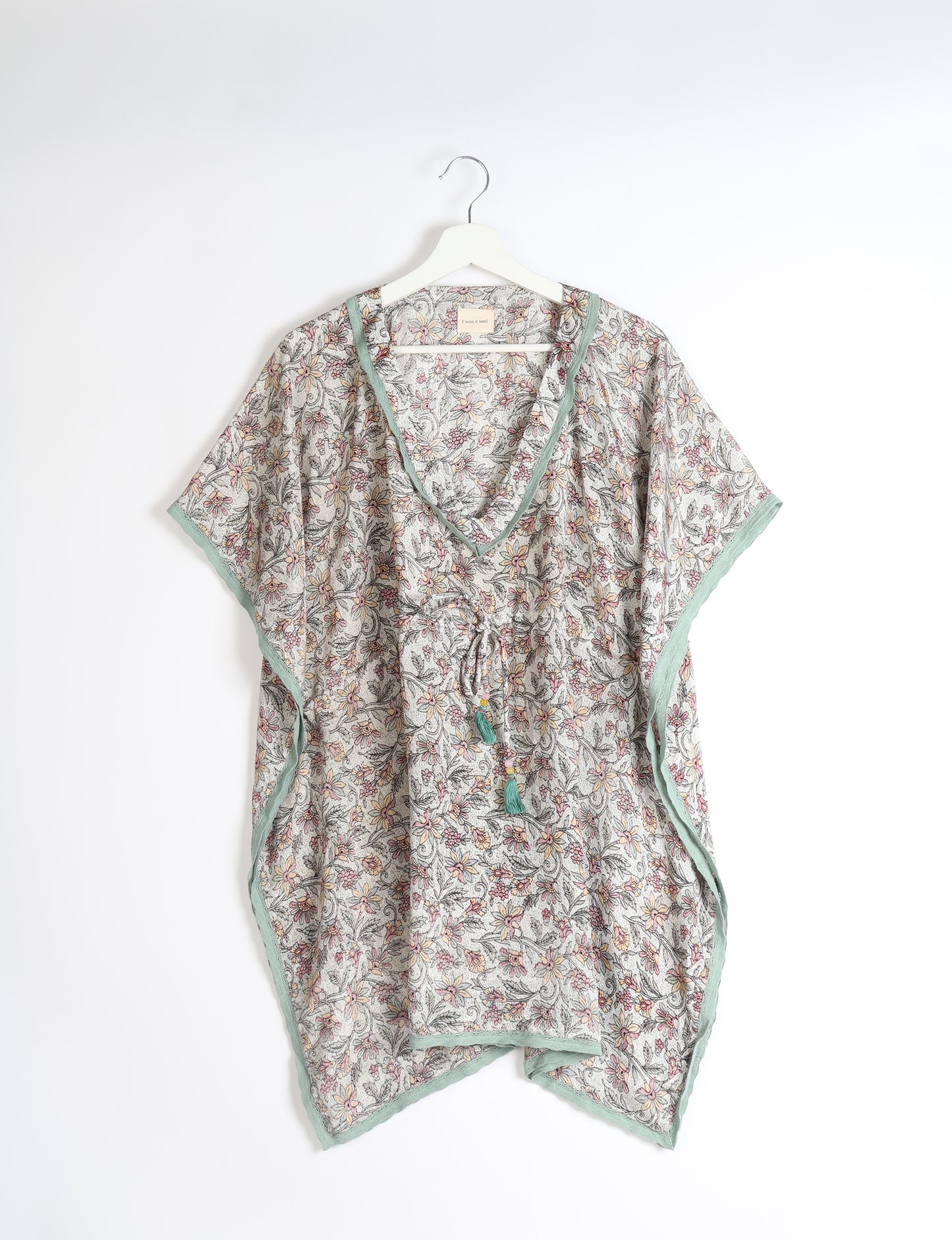 Elevate your style with our short kaftan, a perfect blend of ethical and green fashion. The light and loose-flowing fabric, drawstring waist, beaded tassel ends, and delicate lace edging make it a versatile choice for urban summers, beachwear, or poolside elegance. Enjoy sustainable and fashionable living.