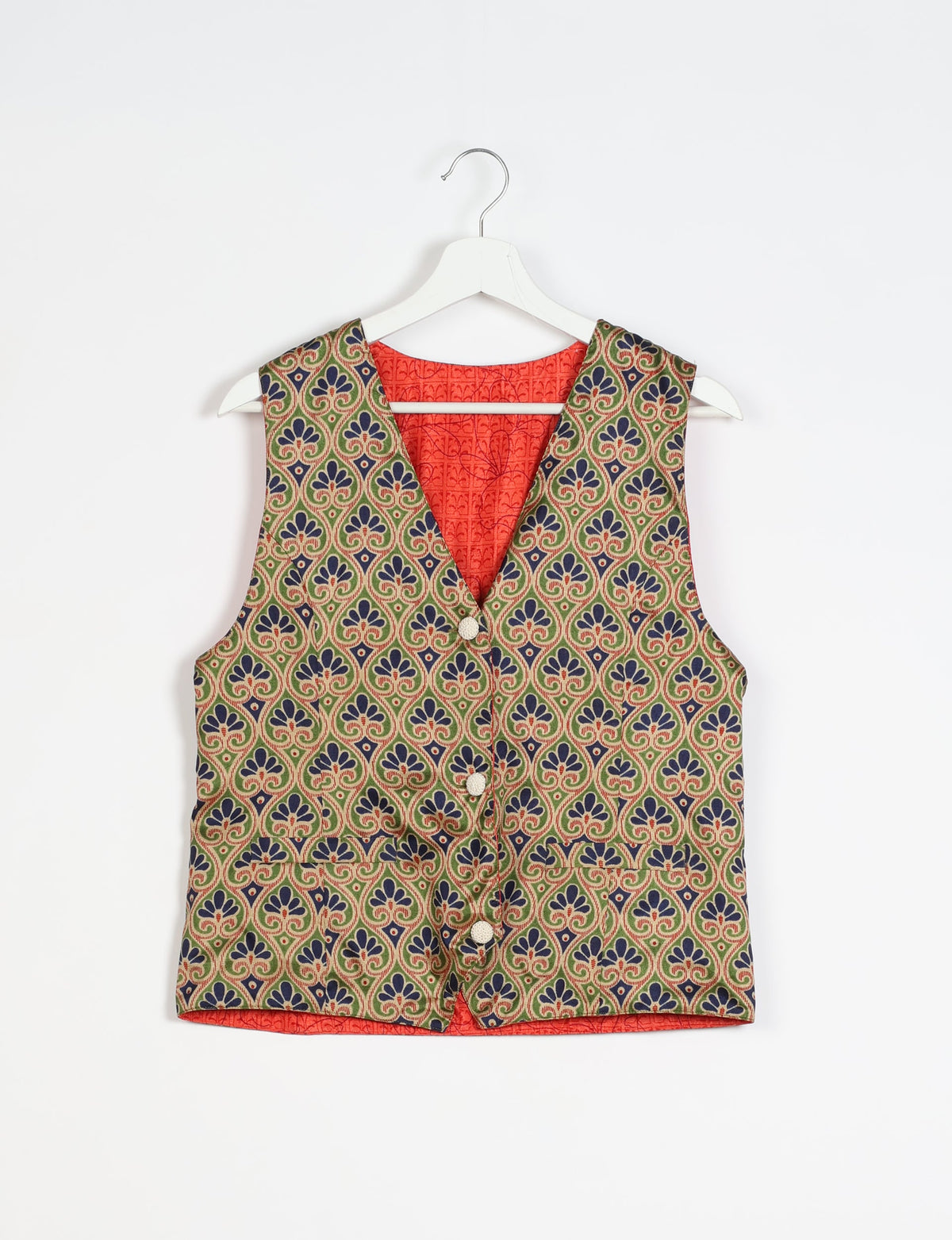 Beige Indian ethnic waistcoat with blue and green floral pattern, front buttons, and red inner lining, hanging on white hanger