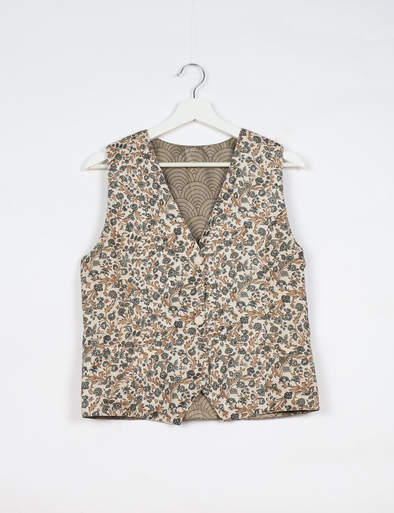 White waistcoat with brown and gray floral print, button front, V-neck, and patterned inner lining, hanging on white hanger