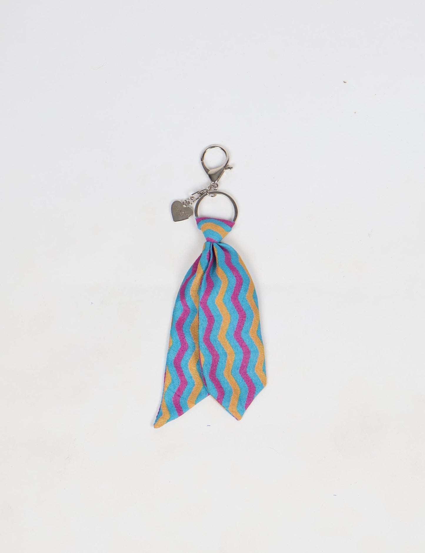 Upcycled sari tie keychain with loop detail, made from recycled fashion waste in vibrant prints—eco clothing accessory for green fashion lovers, promoting slow fashion, recycled material clothing, and climate neutral fashion.