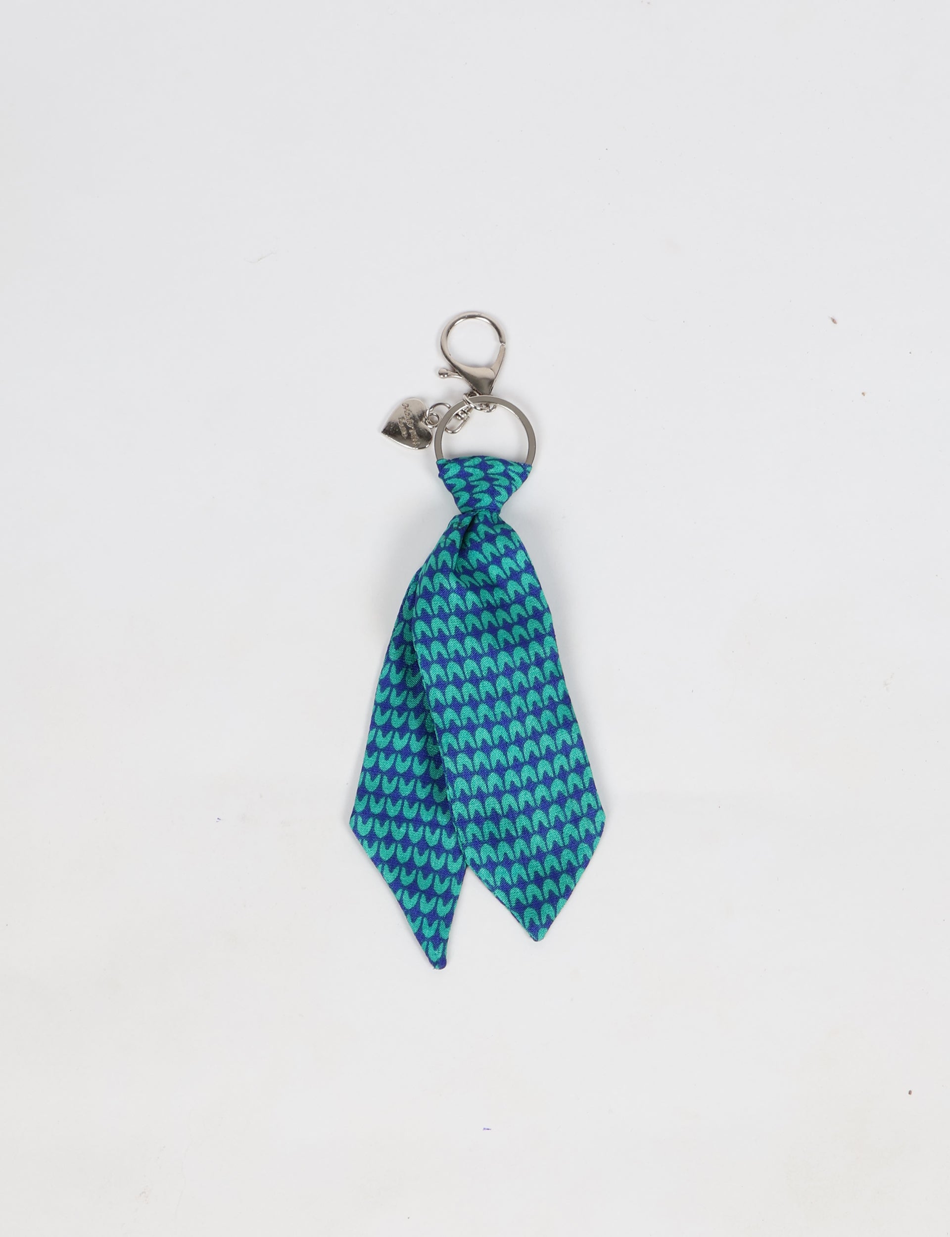 Blue tie keychain with a micro pattern of teal shapes, silver keyring, lobster clasp, and small heart charm attached