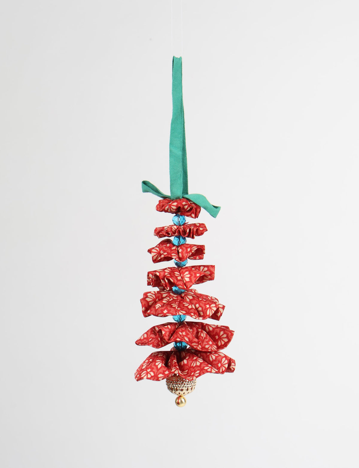 Red fabric Christmas tree ornament with abstract pattern, blue beads, gold bell, and green hanging loop, front view