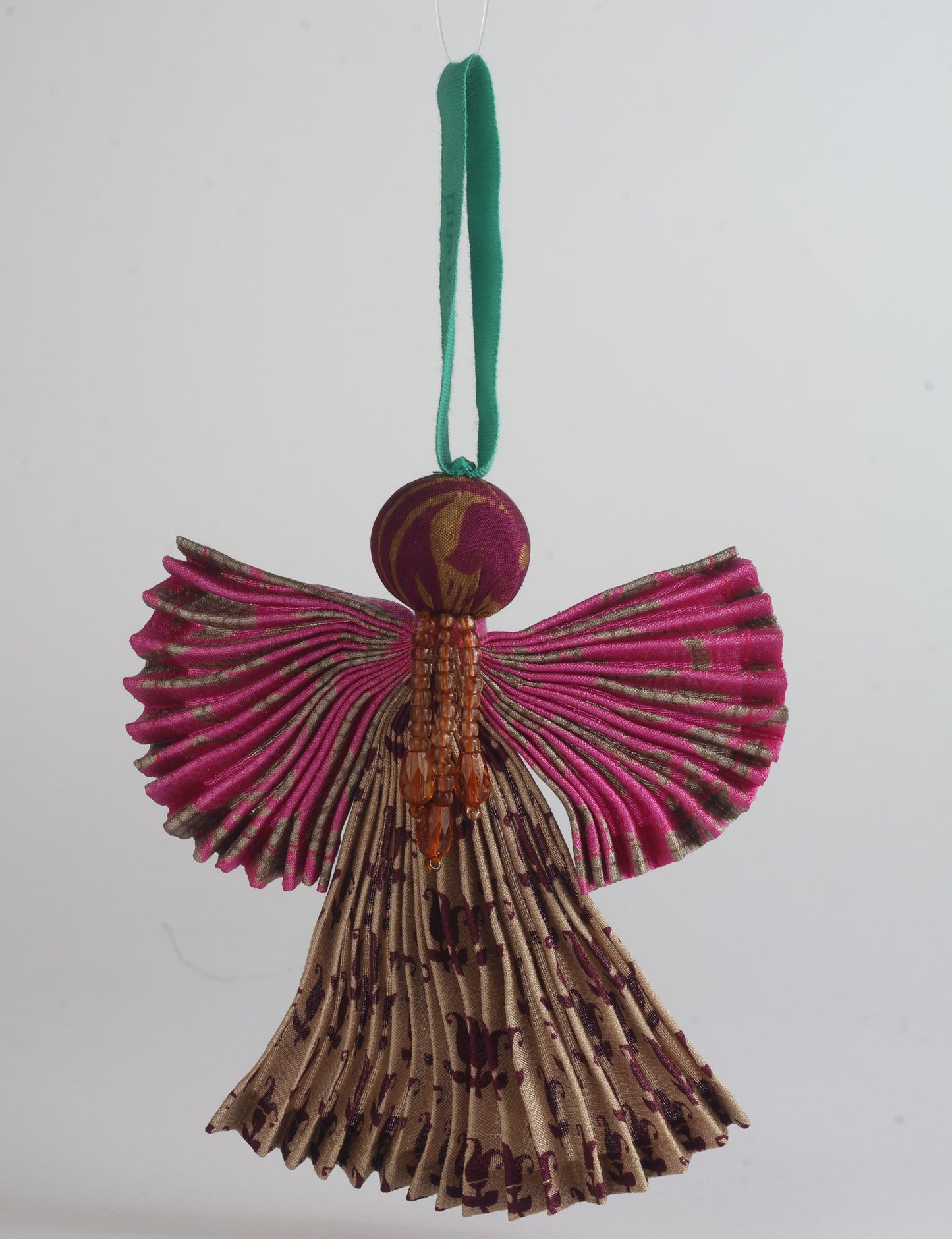 Angel Christmas Ornament made from upcycled saris, featuring pleated arms and body. A sustainable, eco-friendly holiday decoration, embodying recycled fashion and upcycling in festive style.





