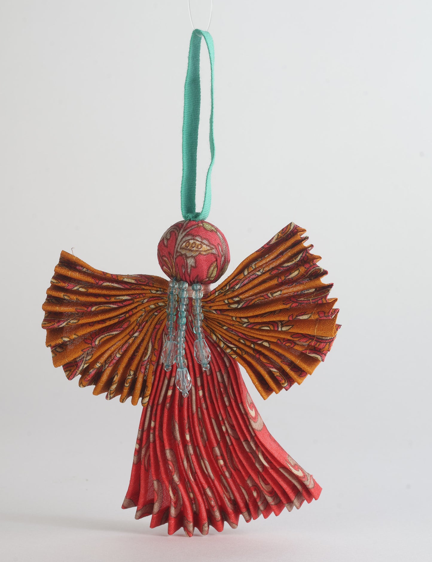 Angel Christmas Ornament made from upcycled saris, featuring pleated arms and body. A sustainable, eco-friendly holiday decoration, embodying recycled fashion and upcycling in festive style.





