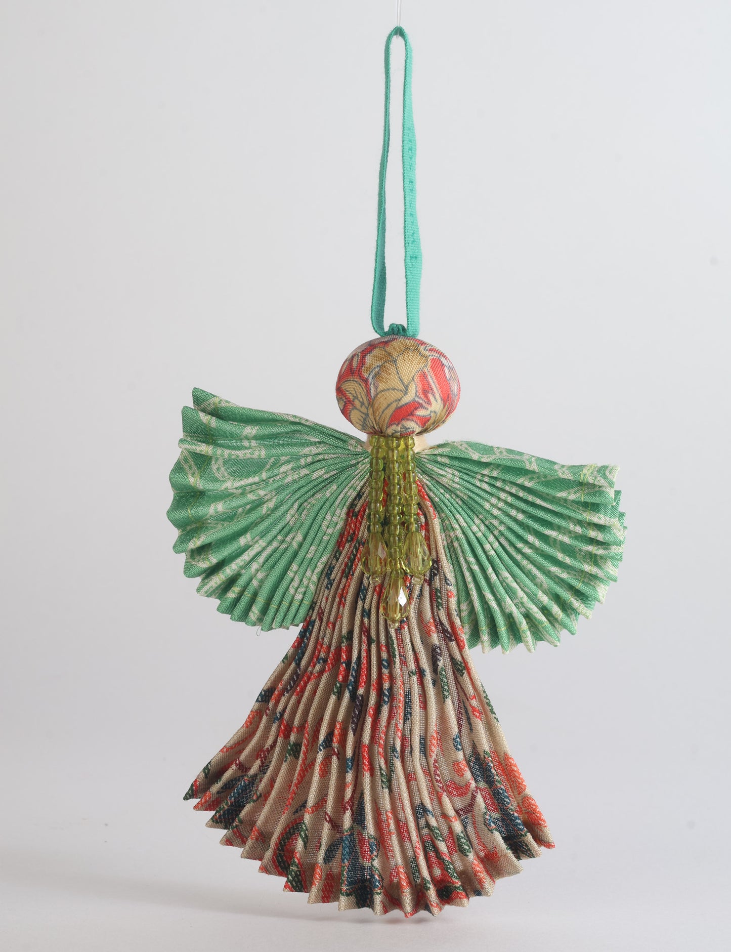 Angel Christmas Ornament made from upcycled saris, featuring pleated arms and body. A sustainable, eco-friendly holiday decoration, embodying recycled fashion and upcycling in festive style.





