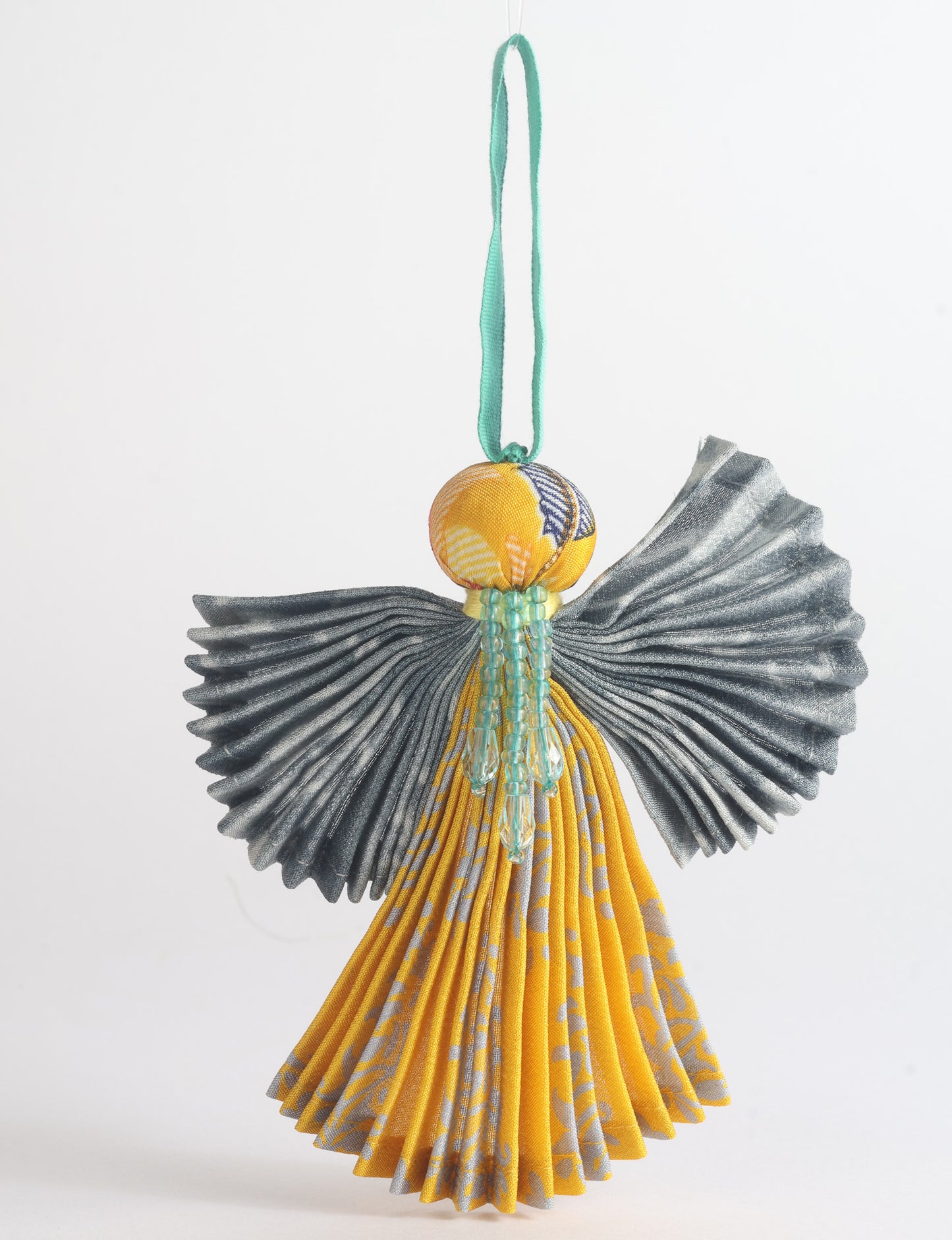Angel Christmas Ornament made from upcycled saris, featuring pleated arms and body. A sustainable, eco-friendly holiday decoration, embodying recycled fashion and upcycling in festive style.





