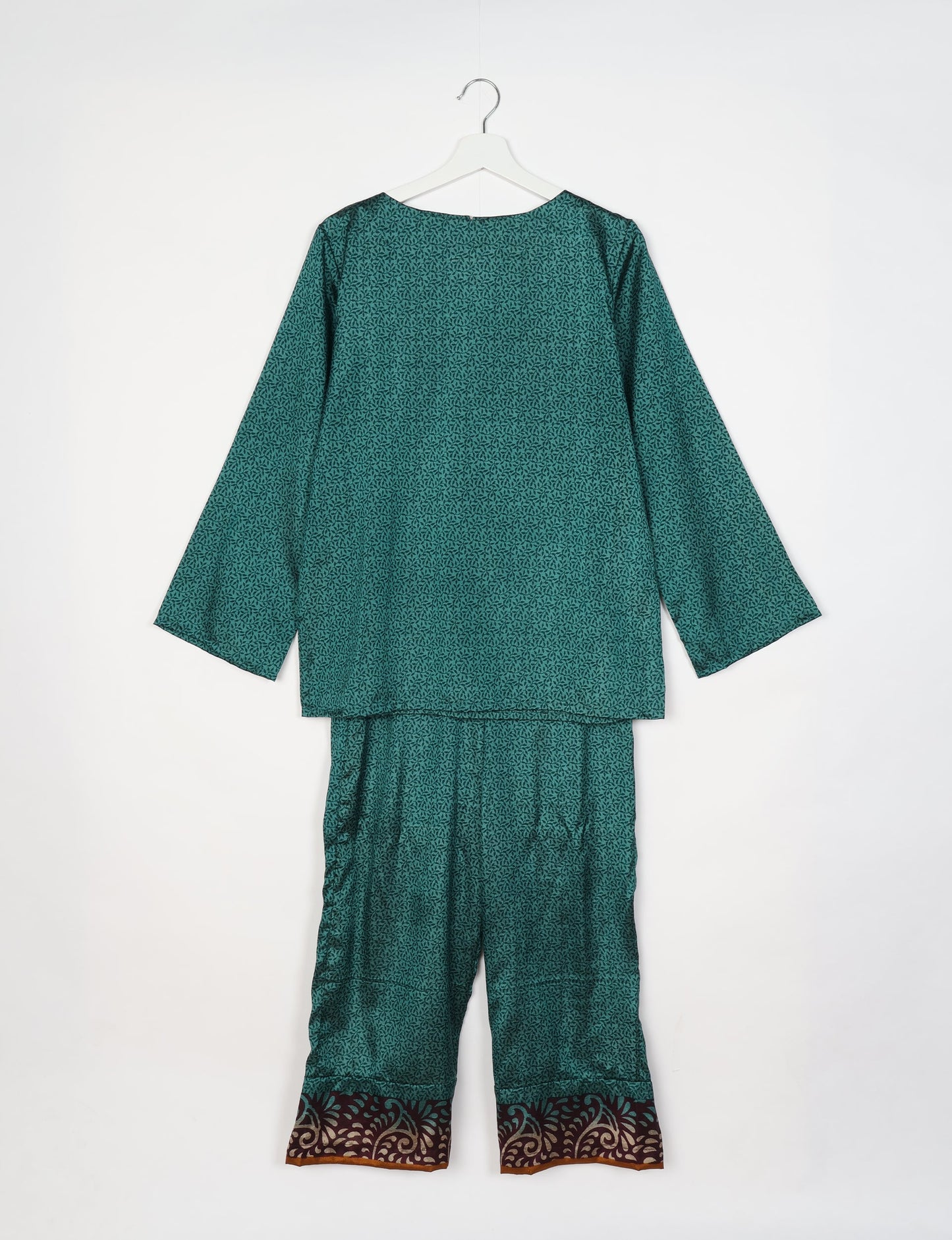 Green lounge set with micro leaf pattern, long sleeves, and pants featuring a contrasting brown and beige floral border