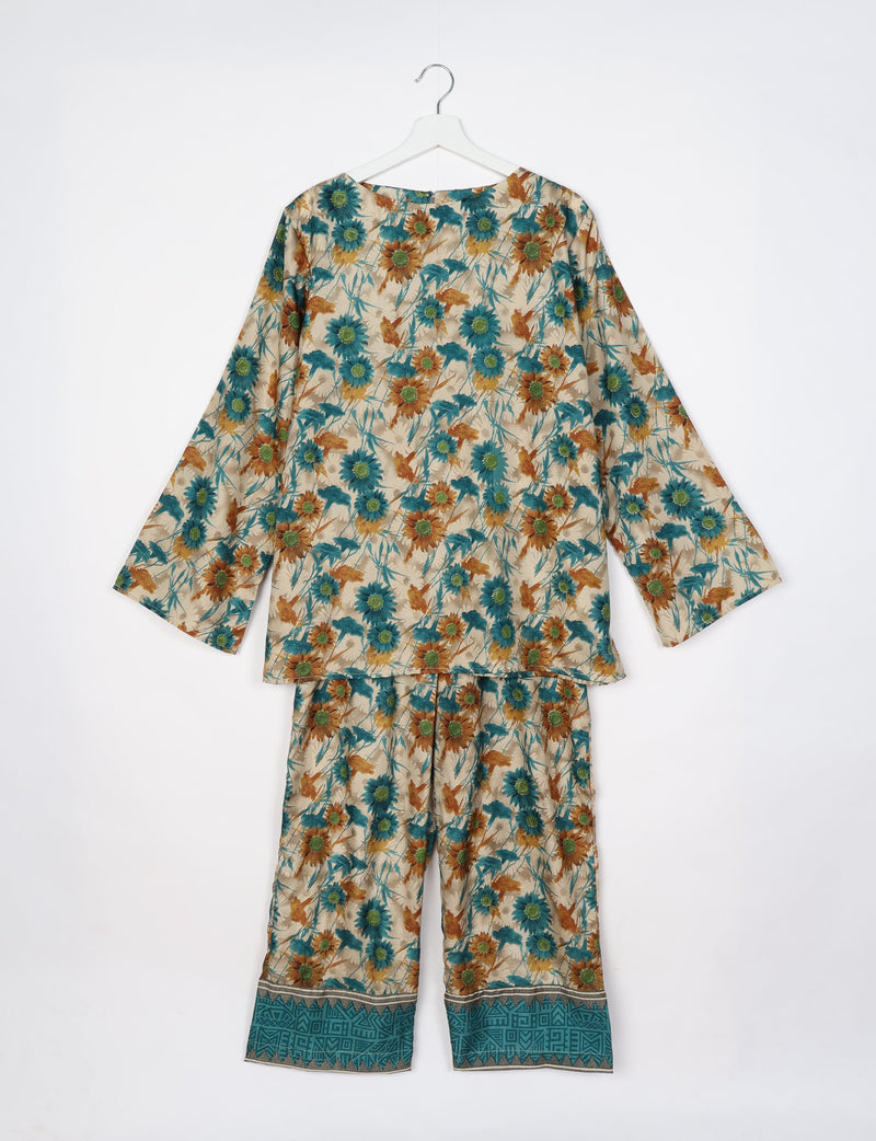 Beige floral lounge set with long sleeves and teal geometric border on pants, shown hanging flat on white background
