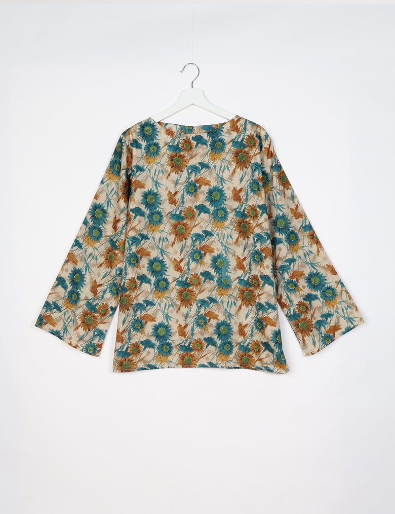 Beige long-sleeve lounge top with blue and brown floral print, round neckline, hanging on white hanger, back view