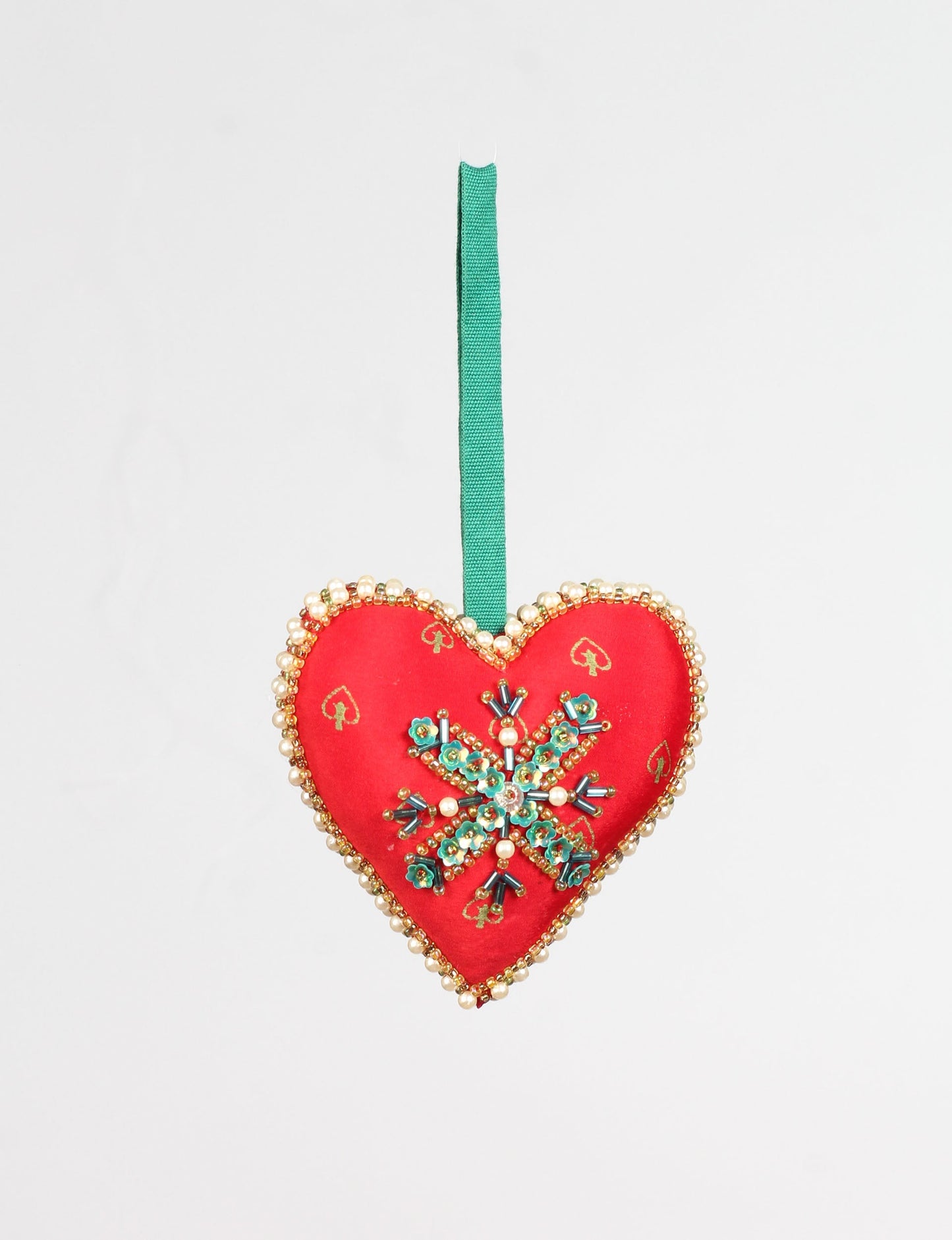 A Christmas heart ornament made from recycled sari fabric, featuring traditional Aari embroidery, representing sustainable, eco-friendly fashion. Handcrafted by artisans, this zero-waste, fair trade product symbolizes recycled material clothing and conscious clothing choices within eco-friendly and circular fashion.