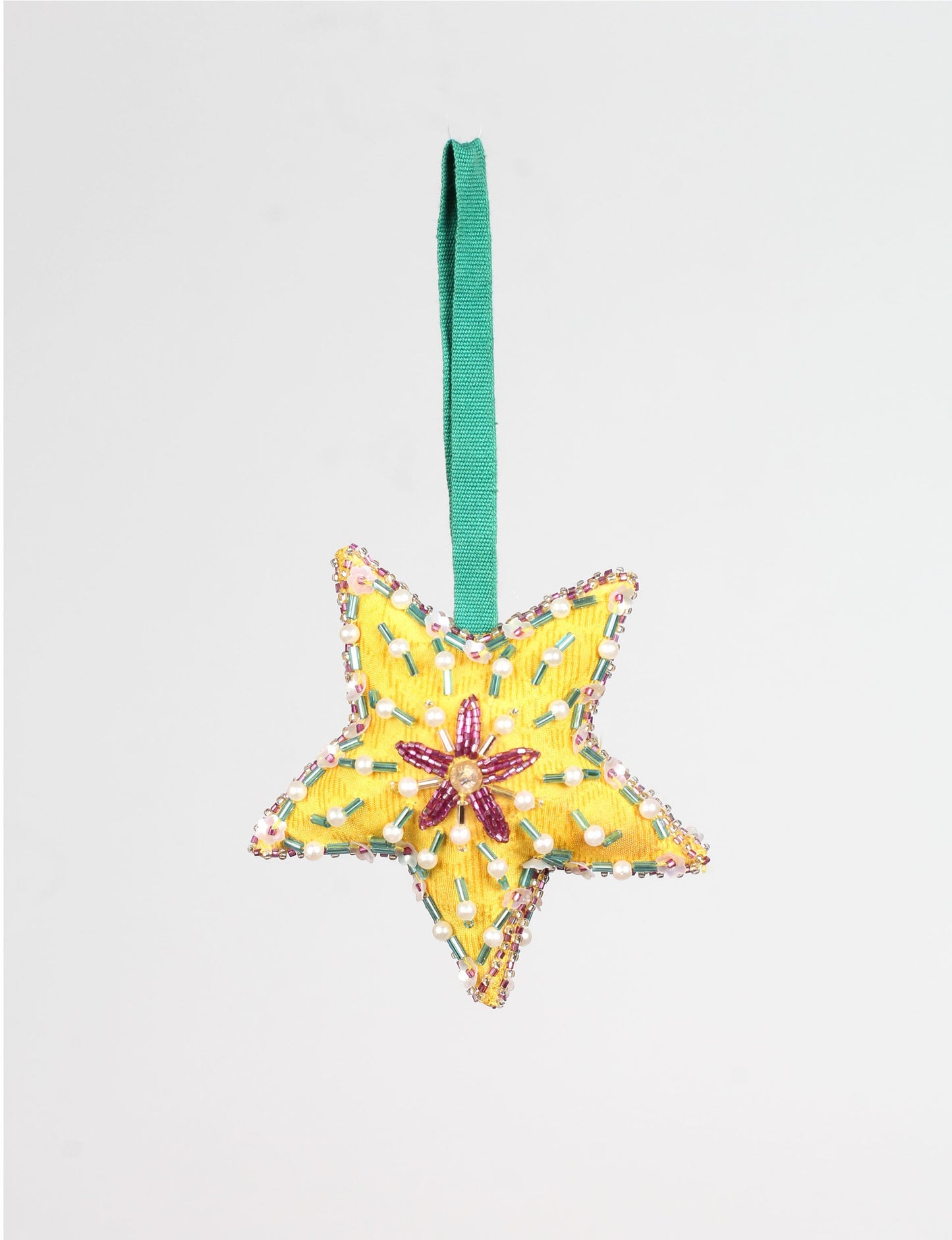 Yellow fabric star ornament with green, pink, and pearl bead embellishments and a green hanging loop