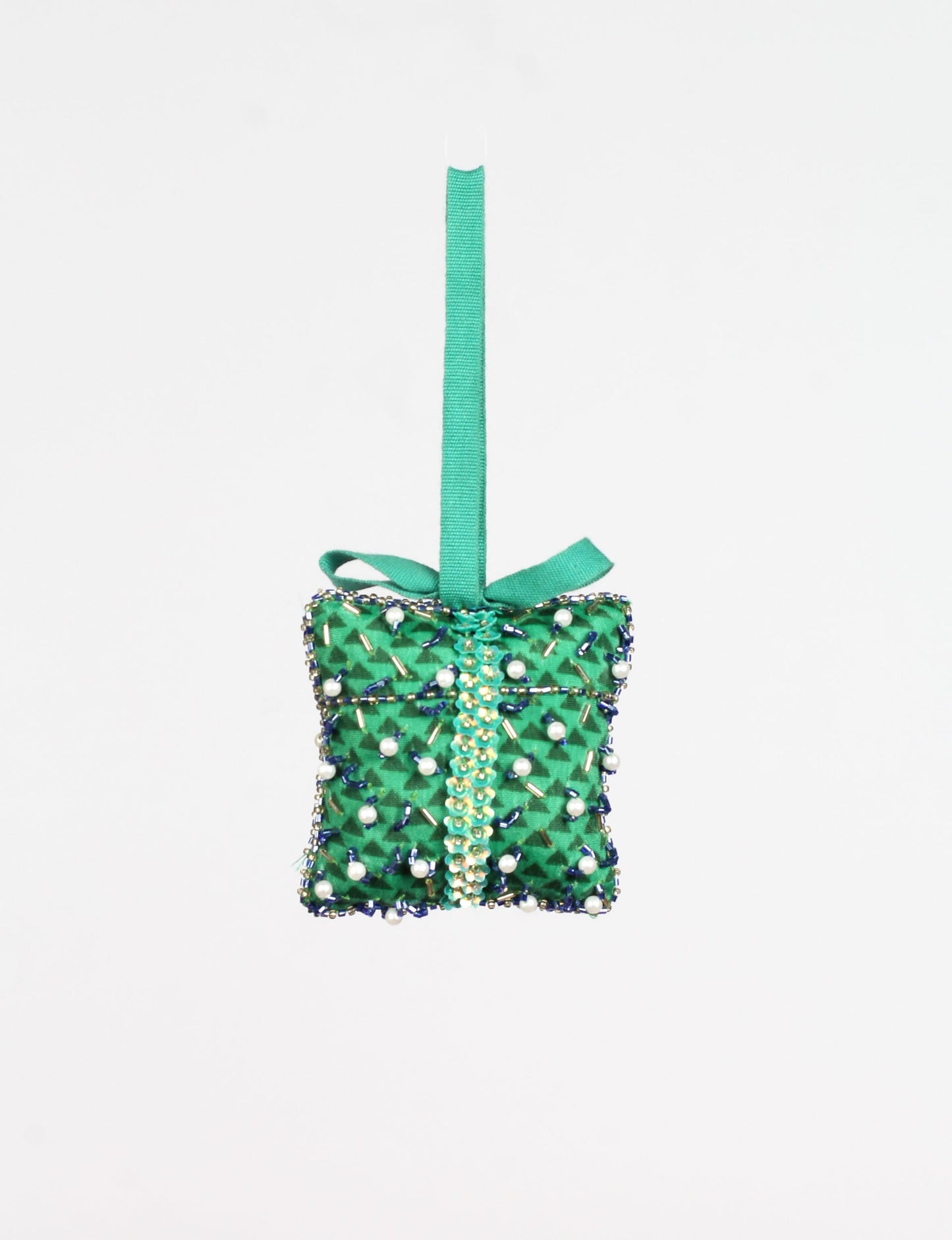 Green fabric gift-shaped ornament with abstract pattern, decorated with beads, pearls, and a green hanging loop with bow