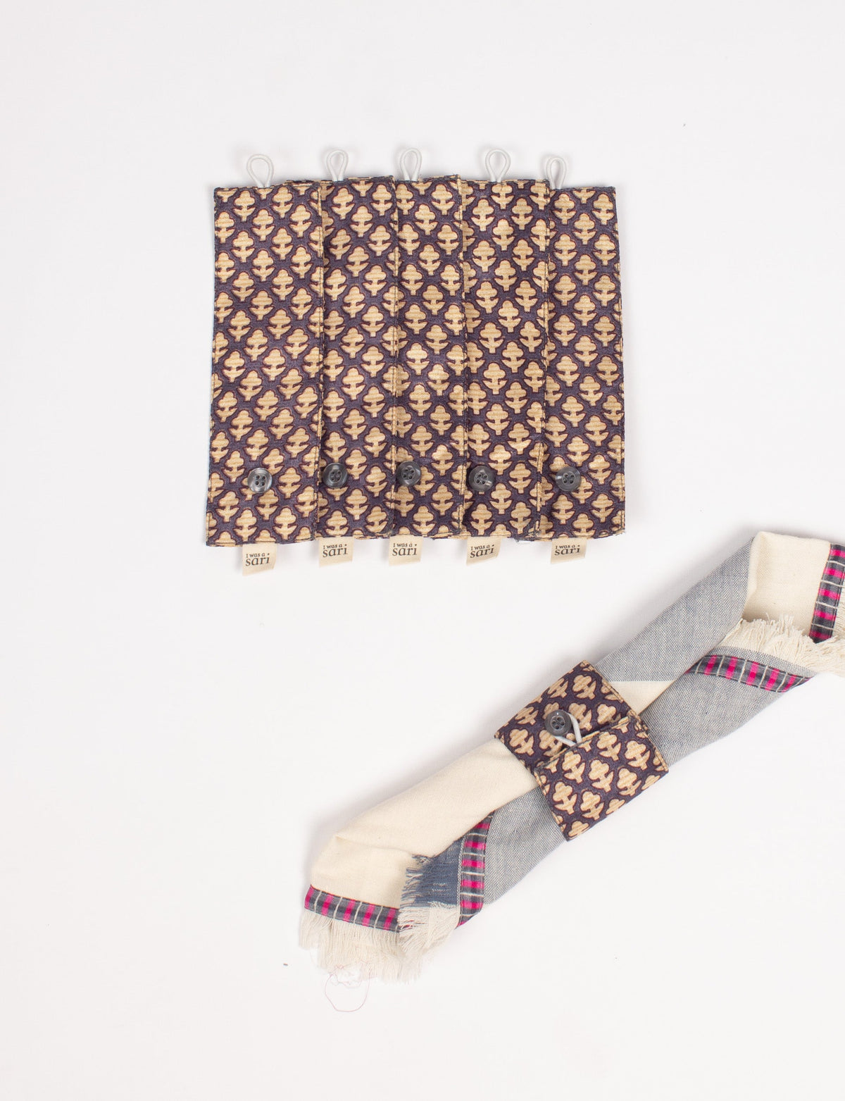 Set of six brown napkin rings with beige micro leaf pattern, button closure, and fabric loop, shown flat with a rolled napkin