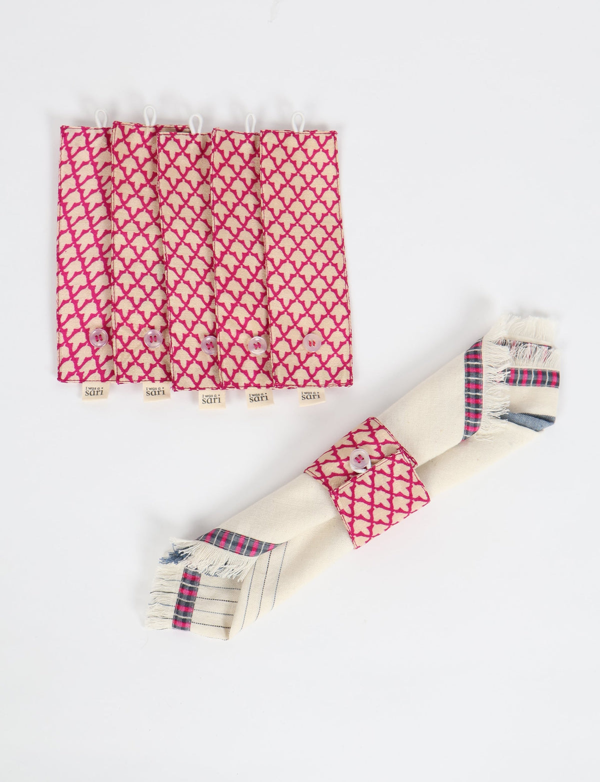 Set of six pink and beige napkin rings with micro geometric pattern and button closure, shown flat and on a folded napkin