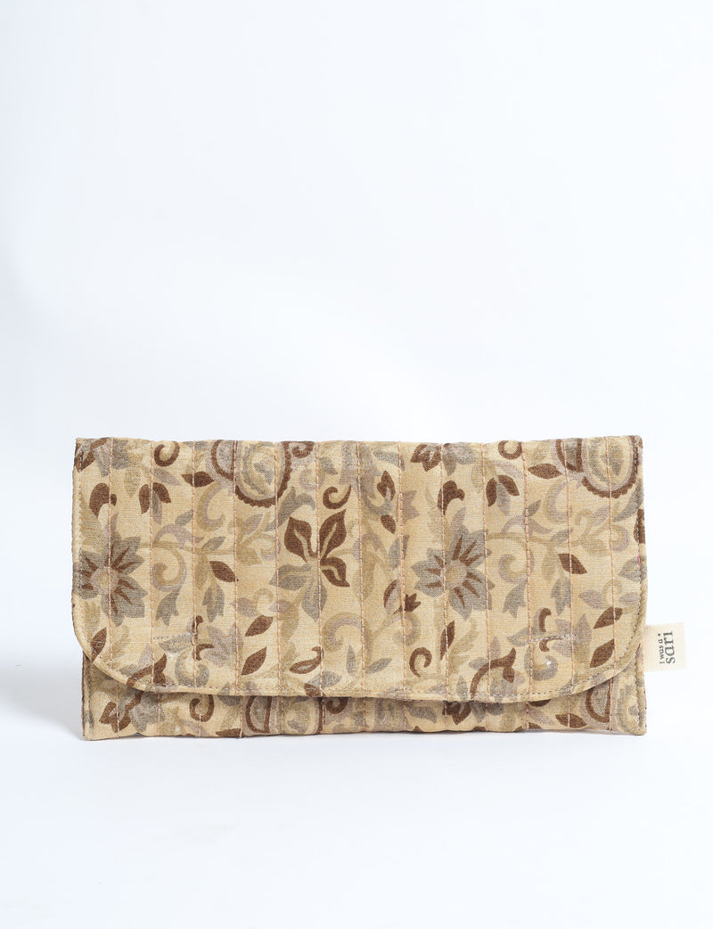 Beige quilted sunglasses case with tropical floral pattern and vertical stitching, shown flat with flap closed and fabric
