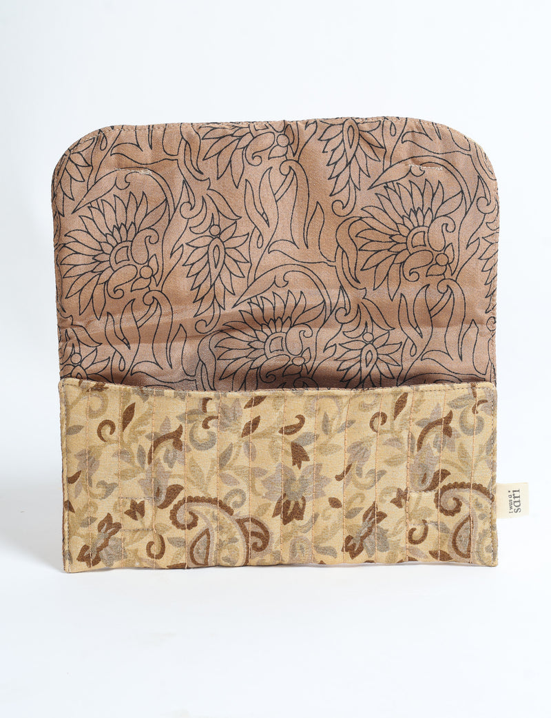 Beige quilted sunglasses case with tropical floral pattern, open flat showing inner and outer fabric designs and label tag