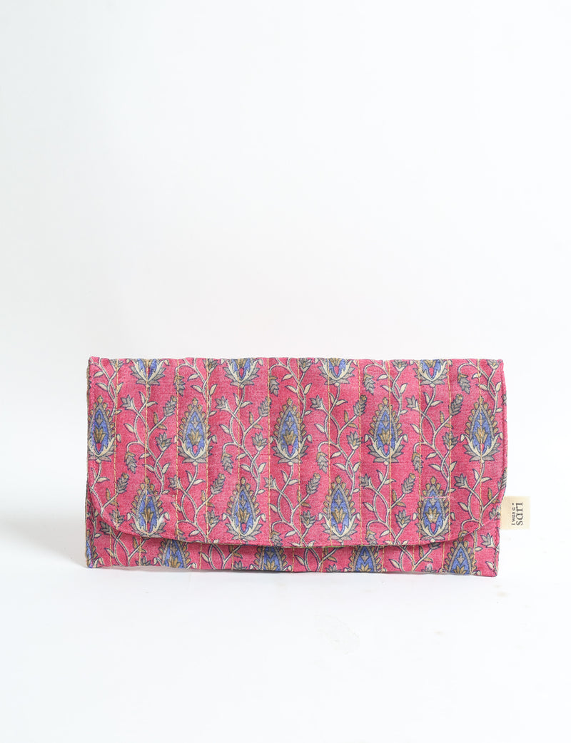 Quilted pink fabric sunglasses case with blue and beige tropical floral pattern, folded with flap and fabric tag on side