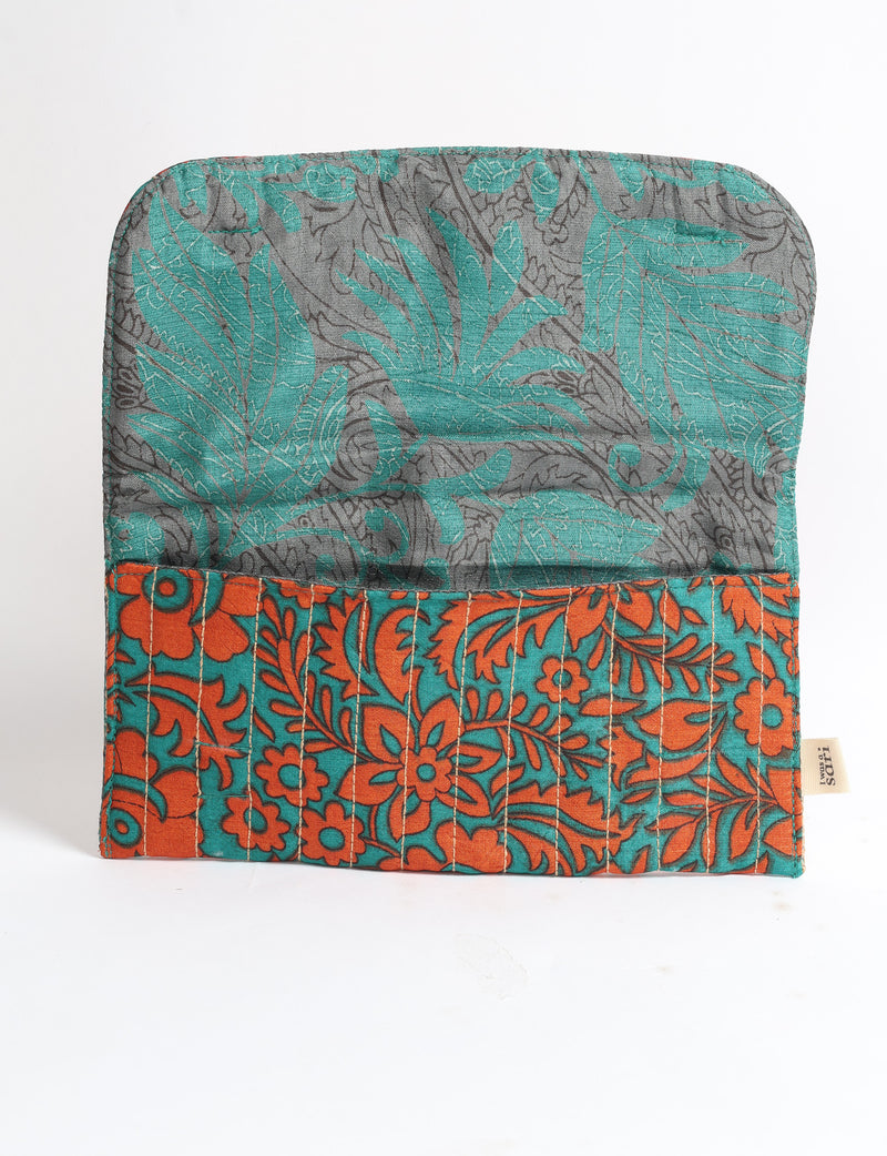 Quilted fabric sunglasses case with orange and teal floral pattern and gray tropical leaf interior, open flat on white background