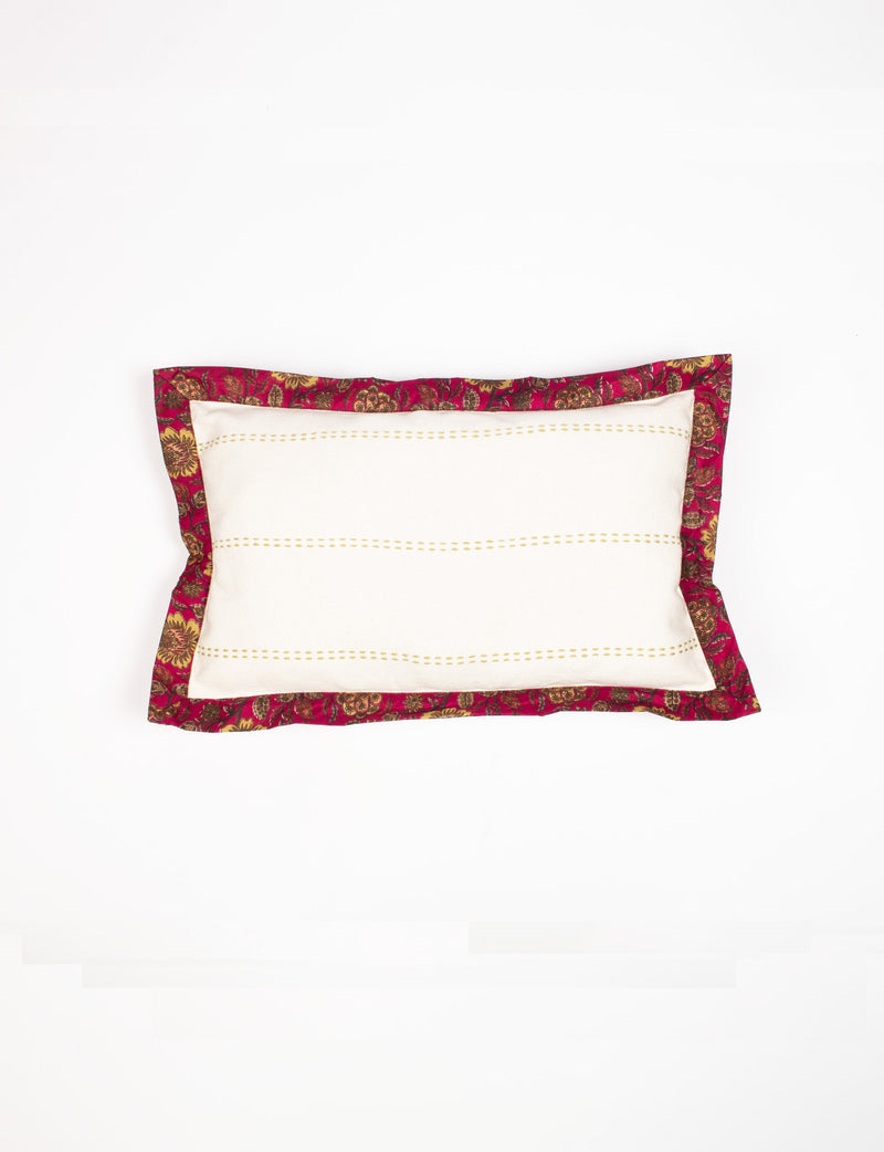 Lumbar cotton cushion cover with cream center, yellow stitched lines, and broad red floral sari edging, flat lay view