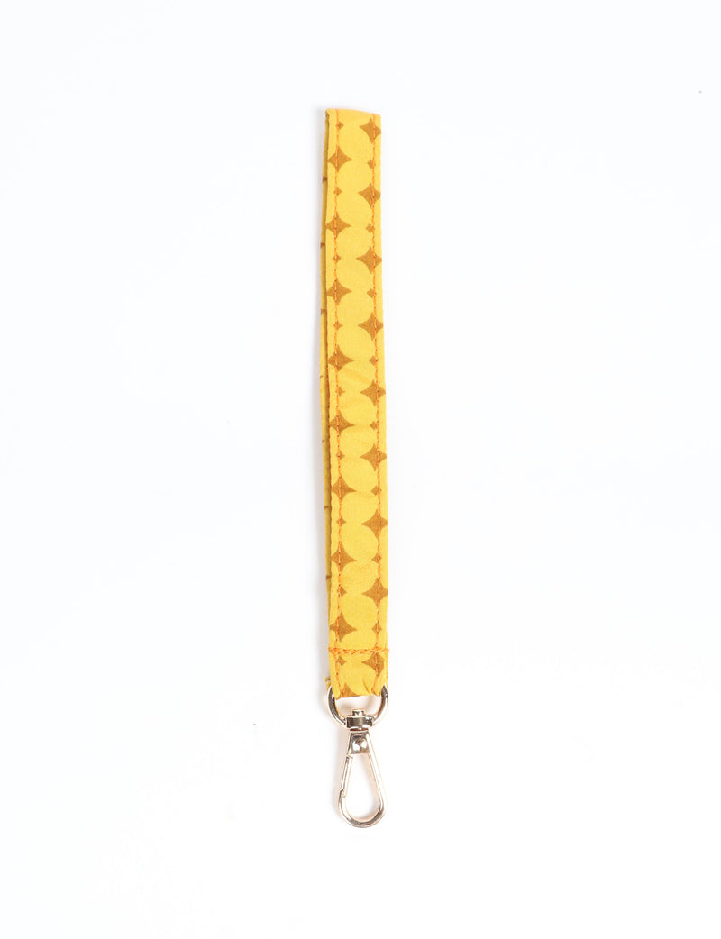 Yellow fabric keychain lanyard with geometric pattern and silver metal clasp, shown flat on white background