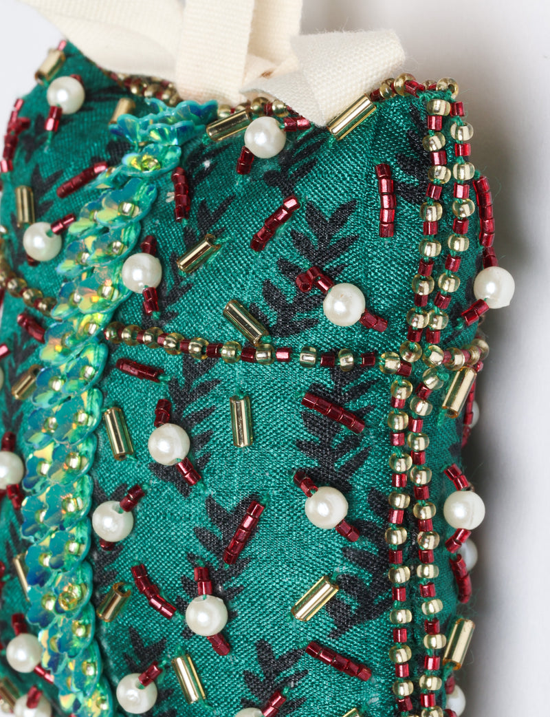 Red fabric ornament decorated with green, gold, pink beads and white pearl-like beads in a detailed pattern