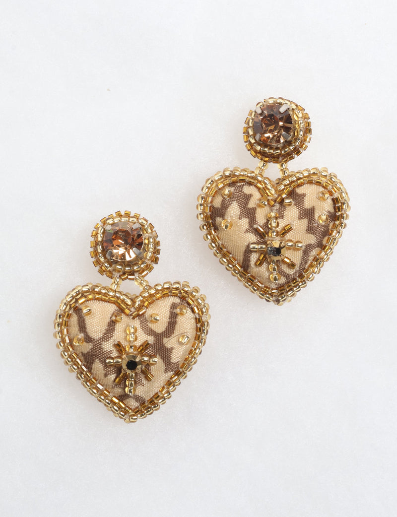 Gold-tone heart drop earrings with brown patterned fabric and bead embellishments, shown on a white background