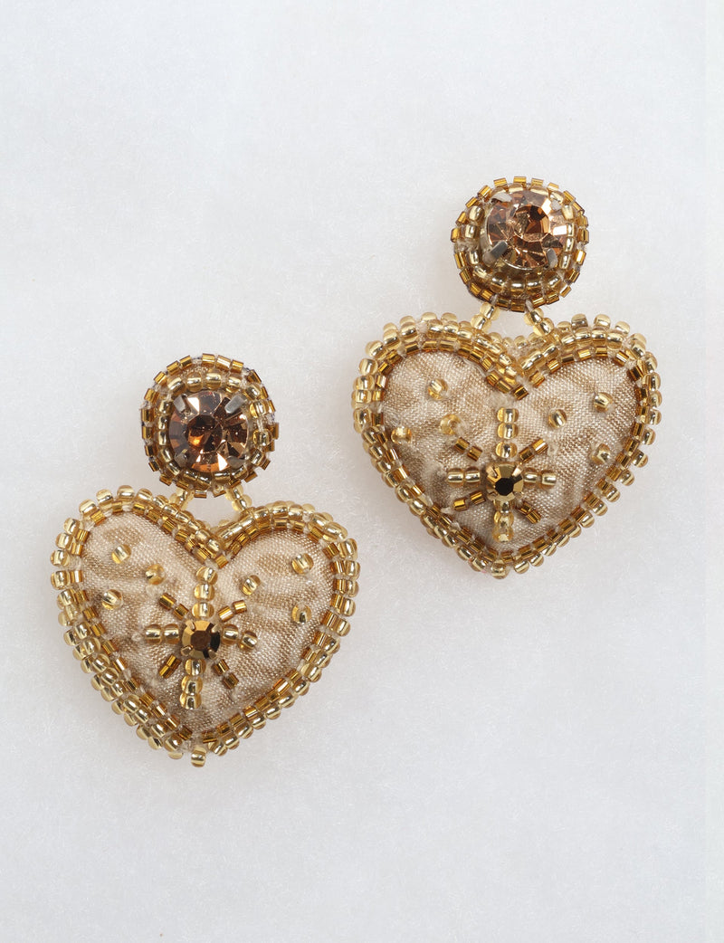 Gold-tone heart drop earrings with bead and rhinestone embellishments, shown in close-up on a white background
