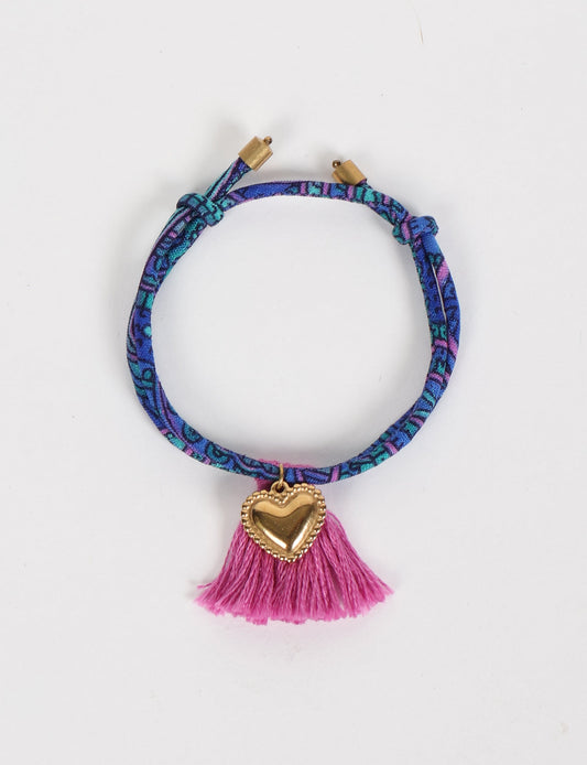 Handmade rope bracelet from recycled sari fabric with gold heart charm and tassels—eco friendly cloth, climate neutral fashion, and upcycled women’s clothing.