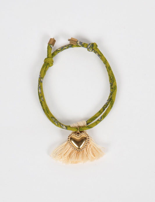 Handmade rope bracelet from recycled sari fabric with gold heart charm and tassels—eco friendly cloth, climate neutral fashion, and upcycled women’s clothing.