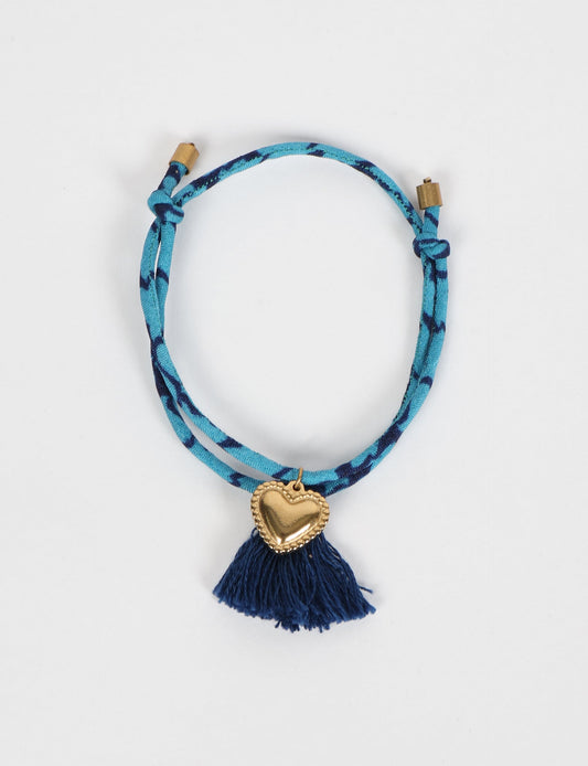 Handmade rope bracelet from recycled sari fabric with gold heart charm and tassels—eco friendly cloth, climate neutral fashion, and upcycled women’s clothing.