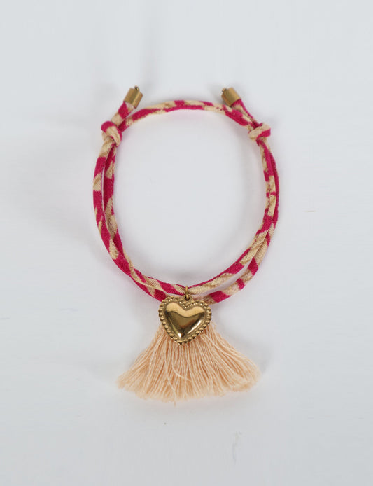 Handmade rope bracelet from recycled sari fabric with gold heart charm and tassels—eco friendly cloth, climate neutral fashion, and upcycled women’s clothing.