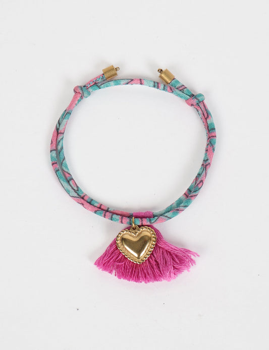 Handmade rope bracelet from recycled sari fabric with gold heart charm and tassels—eco friendly cloth, climate neutral fashion, and upcycled women’s clothing.