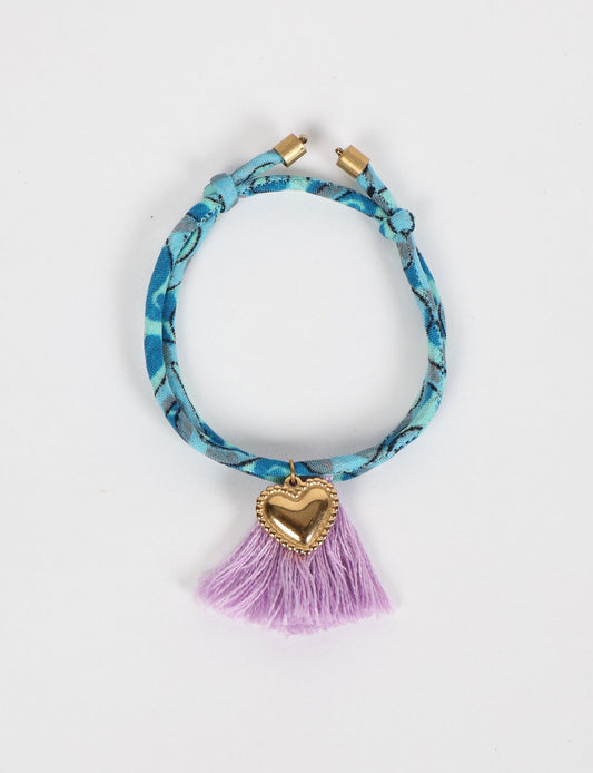 Handmade rope bracelet from recycled sari fabric with gold heart charm and tassels—eco friendly cloth, climate neutral fashion, and upcycled women’s clothing.